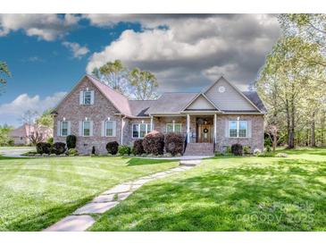 Charming brick home featuring a well-manicured lawn and inviting stone walkway and lush landscaping at 227 Donsdale Dr, Statesville, NC 28625