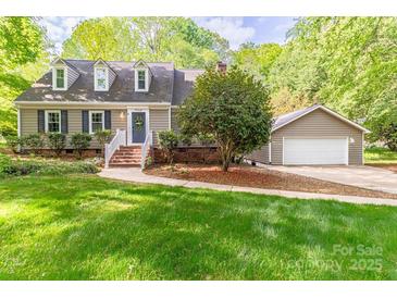 Charming home with a well-manicured lawn, complemented by a detached garage, enhancing its curb appeal at 7514 Pewter Ln, Charlotte, NC 28270
