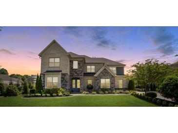 Beautiful two-story home featuring a manicured lawn, stone accents, and tasteful landscaping at 9611 Pensive Ln, Waxhaw, NC 28173