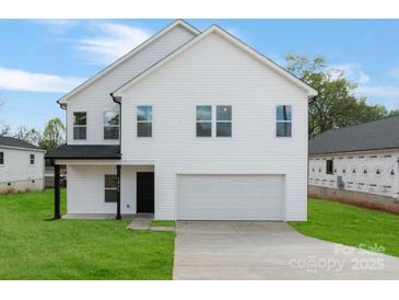 Charming two-story home with white siding, attached garage, and well-maintained lawn at 1041 Secor St, Statesville, NC 28677