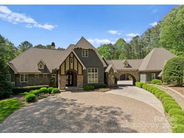 Stunning home features a circular driveway and porte-cochère, all surrounded by lush landscaping at 10915 Hermit Thrush Ln, Charlotte, NC 28278