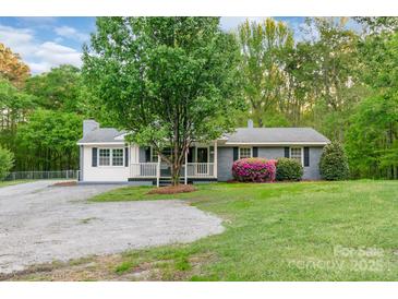 Charming single-story home featuring a cozy front porch, mature tree, and well-manicured lawn at 1106 University Dr, Lancaster, SC 29720