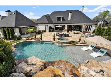 Beautiful backyard oasis featuring a large pool, jacuzzi, and ample seating at 129 Hunts Landing Dr, Mooresville, NC 28117