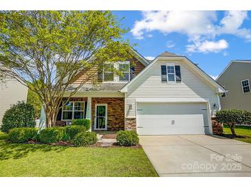 Charming two-story home featuring a brick and siding exterior, a two-car garage, and a well-manicured lawn at 13715 Sunrise View Dr, Charlotte, NC 28278