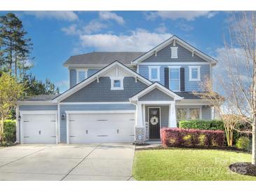 Charming two-story home boasts a well-manicured lawn, three-car garage, and beautiful blue siding at 2030 Bosna Ln, Fort Mill, SC 29715