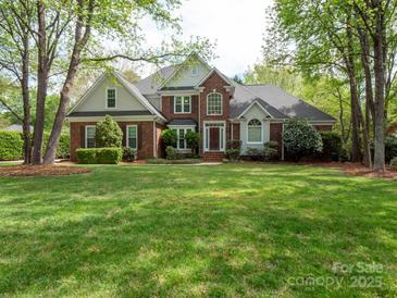 Beautiful brick home with a manicured lawn, mature trees, and a welcoming entrance at 4721 Myers Ln, Harrisburg, NC 28075