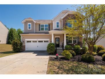 Charming two-story home featuring a well-manicured lawn, stone accents, and an attached two-car garage at 6061 Piscataway Ct, Rock Hill, SC 29732