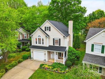 Charming two-story home boasts lush landscaping, a welcoming porch, and an attached garage for modern suburban living at 9209 Rotherham Ln, Charlotte, NC 28216