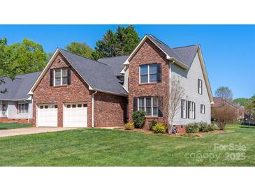 Charming brick and siding home with a well-manicured lawn and attached two-car garage at 1050 Merrywood Dr, Newton, NC 28658