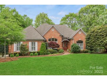 Charming brick home featuring manicured lawn, mature trees, and inviting curb appeal at 11424 Stonebriar Dr, Charlotte, NC 28277