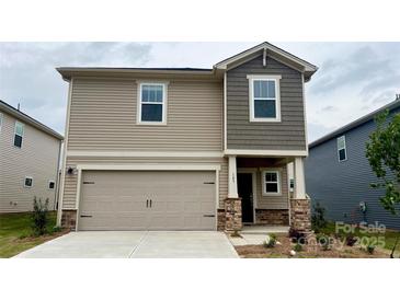 Two-story home with a two-car garage and stone accents, featuring neutral toned siding and a covered porch at 143 Shepherds Landing Dr, Mooresville, NC 28115