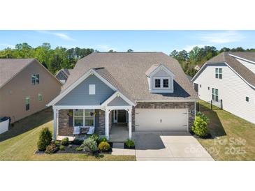 Charming home with stone accents, covered porch, and well-manicured lawn in a beautiful residential neighborhood at 15710 Oleander Dr, Charlotte, NC 28278