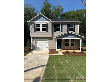 Charming two-story home with a garage, blue shutters, and a well-maintained lawn at 204 Plyler St, Lancaster, SC 29720