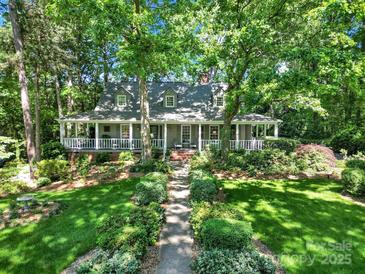 Charming home with a sprawling front porch and beautifully landscaped front yard with mature trees at 4 Hummingbird Ct, Clover, SC 29710