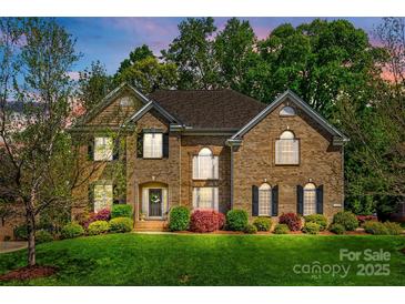 Beautiful two-story brick home with a well-manicured lawn and colorful landscaping at 405 Five Leaf Ln, Waxhaw, NC 28173