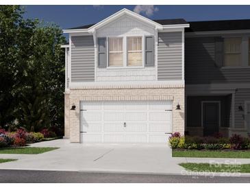 Charming two-story townhome with brick accents, an attached garage, and manicured landscaping at 4301 Summit Woods Dr, Charlotte, NC 28216