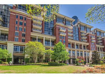 Stunning brick condominium building with balconies, lush landscaping, and verdant lawn area on a sunny day at 435 S Tryon St, Charlotte, NC 28202