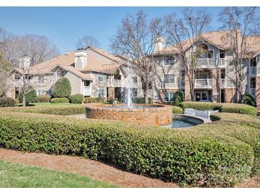 Beautiful condo community featuring lush landscaping, water fountain, and inviting residential buildings on a sunny day at 5007 Sharon Rd # R, Charlotte, NC 28210