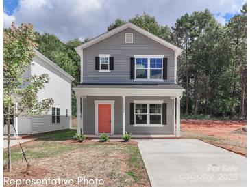 Charming two-story home with gray siding, a bright coral door, and well-manicured landscaping at 552 Ridge Ave, Mooresville, NC 28115