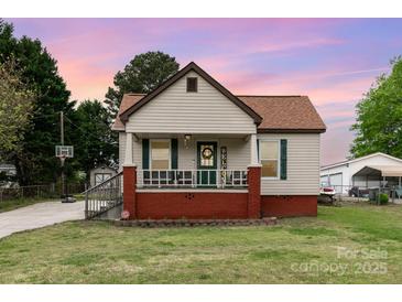Charming single-story home featuring a welcoming front porch and a well-maintained lawn at 557 Hunter Ave, Kannapolis, NC 28083