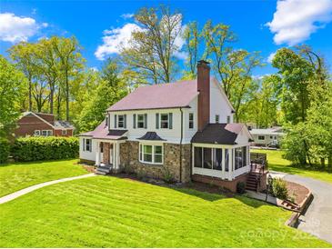 Charming two-story home with stone accents, complemented by lush green lawn and mature trees at 621 N 9Th St, Albemarle, NC 28001