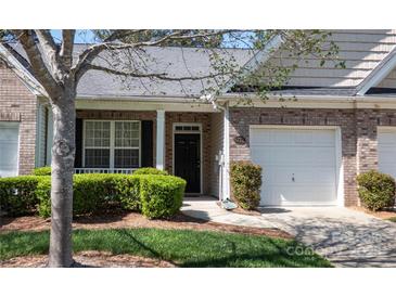 Charming brick townhome featuring a well-manicured lawn, one-car garage, and inviting front entrance at 6222 Meadow Glen Ln, Harrisburg, NC 28075