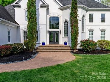 Elegant front entrance with double doors, tall windows, manicured trees and brick walkway at 1700 White Pond Ln, Waxhaw, NC 28173