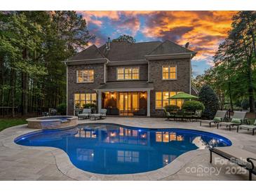 Stunning backyard features a large pool, spa, and outdoor seating area, perfect for entertaining and relaxation at 1717 Brawley School Rd, Mooresville, NC 28117