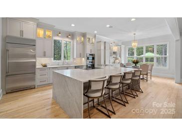 Bright, modern kitchen with a large island, stainless steel appliances, and hardwood floors at 1717 Brawley School Rd, Mooresville, NC 28117