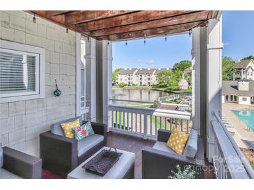 Charming patio features wicker seating, wooden pergola, and scenic waterfront view at 18832 Nautical Dr # 41, Cornelius, NC 28031