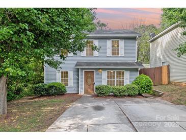 Charming two-story home with light-blue siding, white shutters, well-maintained landscaping, and a concrete driveway at 248 Pangle Dr, Charlotte, NC 28217