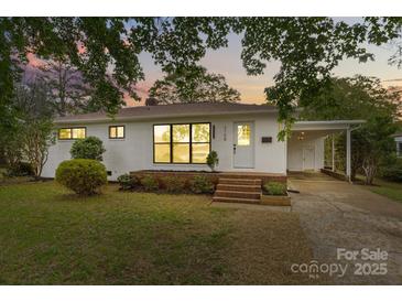 Charming one-story home with white brick, new windows, front yard with green lawn and landscaped features at 3108 Anne St, Charlotte, NC 28205