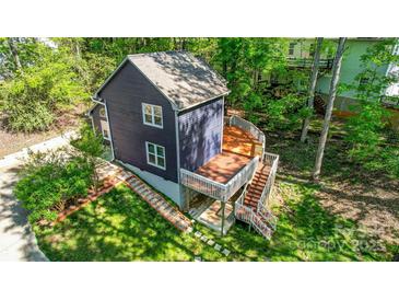 View of the back of the home with a large wooden deck and a lush green lawn at 4036 Windward Dr, Tega Cay, SC 29708
