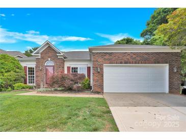 Charming brick home featuring a two-car garage and a well-maintained front yard at 4155 Guilford Nw Ct, Concord, NC 28027