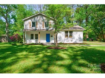 Charming two-story home with lush green lawn and mature trees, a blue front door, and freshly painted white brick at 4313 Sudbury Rd, Charlotte, NC 28205