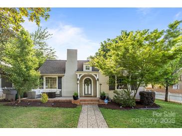 Charming home with brick walkway, front porch, well-manicured lawn, and mature landscaping under a bright blue sky at 700 Oakland Ave, Charlotte, NC 28204