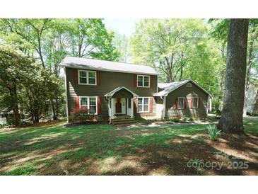 Charming two-story home with a well-manicured lawn, mature trees, and quaint red shutters, blending comfort and curb appeal at 1174 Orchard Dr, Fort Mill, SC 29715