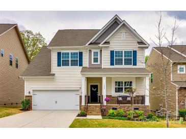 Charming two-story home with a well-manicured lawn, inviting front porch, and pleasing architectural details at 1588 Trentwood Dr, Fort Mill, SC 29715