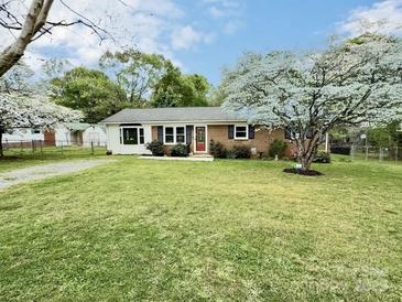 Charming single-story brick home featuring a well-maintained lawn and mature flowering trees at 171 Westmoreland Rd, Mooresville, NC 28115