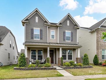 Charming two-story home with a welcoming front porch and well-maintained landscaping at 6433 Raffia Rd, Charlotte, NC 28277