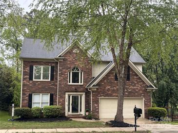 Charming two-story brick home with an attached two-car garage and well-manicured landscaping at 7409 Tarland Ln, Charlotte, NC 28269