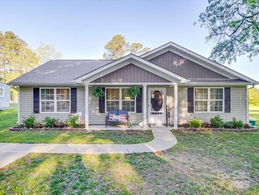 Charming single-story home with inviting front porch, beautiful landscaping, and a welcoming entrance at 833 Generation Ln, Clover, SC 29710