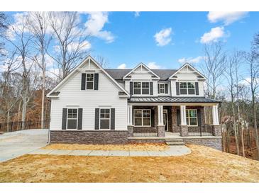 New construction home showcasing traditional architectural style, complete with stone accents and a welcoming front porch at Tbd Boomer Ct # 5, Statesville, NC 28677
