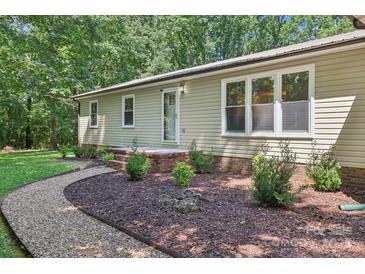 Charming home exterior with a well-manicured lawn and lush landscaping adding curb appeal at 119 Legacy Ln, Harmony, NC 28634