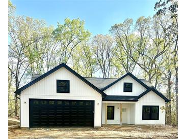 Charming new construction home with black trim, a two-car garage, and vertical siding at 210 Carolina Dr # 1000&999, Troy, NC 27371