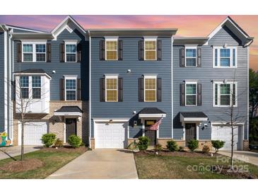 Charming blue townhouse with well-manicured lawn and inviting entrance; a great curb appeal and modern design at 2410 Dr Carver Rd, Charlotte, NC 28208