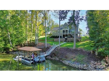 Beautiful two-story gray home with landscaped yard and private dock on a wooded waterfront lot at 3915 Chevlot Hills Rd, Sherrills Ford, NC 28673