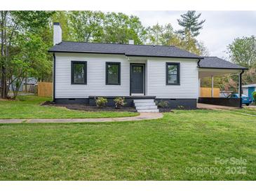 Charming home featuring a well-manicured lawn, covered parking, and a classic white exterior with black trim at 601 Whisnant St, Shelby, NC 28150