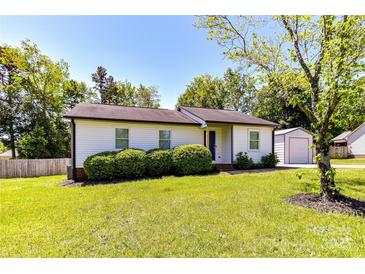Charming single-story home featuring mature landscaping and a detached garage at 8210 Lantana Dr, Denver, NC 28037