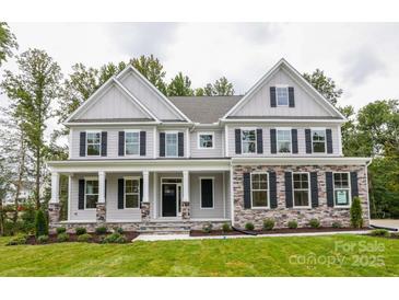 Charming two-story home features stone accents, a covered porch, black shutters and manicured lawn at Tbd Boomer Ct # 6, Statesville, NC 28677
